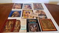 Front view of the eleven items including books, postcard set, and diary all featuring Tutankhamun and Egyptian themes arranged on a table.