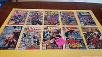 Ten X-Men related Marvel Comics laid out on a table, showing front covers with colorful illustrated artwork depicting various characters.