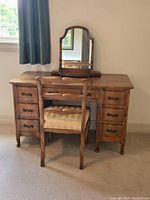 Full view of vintage wood vanity desk with mirror and chair in room corner