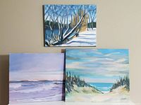 Three oil paintings on canvas displayed on a wall, showing various landscape and seascape scenes in pastel and cool tones.