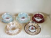 Group photo of all 5 tea cups and 5 saucers in various designs including commemorative Canada 1957