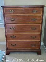 Front view of Henredon high boy chest of drawers showing five drawers and metal handles.