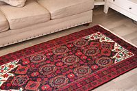 Rug laid out in front of beige sofa showing full design.