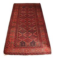 Full view of the Baluch rug laid flat against a white background.