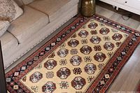 Carpet laid out in living room with beige couch and decorative items for scale and context.