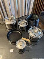 Full view of all cookware items together with storage bag on a table