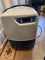 Front view of Simplicity dehumidifier showing control panel with digital display and ventilation grill below.