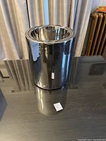 Full view of standing dog water dish showing cylindrical shape and reflective chrome finish.
