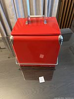 Front and top view of the red Williams Sonoma cooler with metal handle and shiny finish.