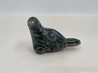 Side view of the soapstone seal figurine showing the textured flippers and head.