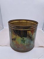 Front view of large brass planter showing vertical panels and patina.