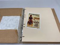 Cover page of the stamp album showing a vintage Propaganda poster stamp for Women's Land Army mounted on an empty page.
