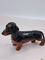 Side profile photo showing the full dachshund figurine with glossy finish and detailed coloring.