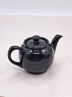 Front angle view of the black Sadler tea pot showing handle, spout, and lid with steam holes.