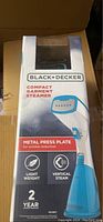 Front view of boxed Black & Decker compact garment steamer with branding and key features visible.