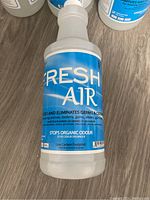 Single Fresh Air sanitizer spray bottle on wood floor.