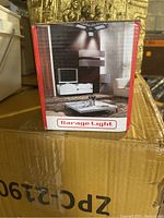 Photo of the front of the box showing the Garage Light and its placement in a room with a TV and seating area.