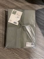 Packaged green queen duvet cover tied with ribbon