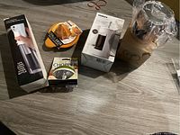 Photo showing all five items including citrus juicer, garlic chopper, oil spray bottle, boxed carafe, and wooden pitcher.