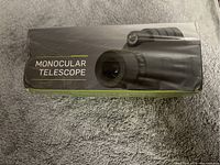 Photo of the product packaging showing the label 'Monocular Telescope' with an image of the telescope on the box.