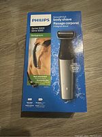 Front view of Philips Series 5000 body groomer box showing body shaver and back attachment in packaging.