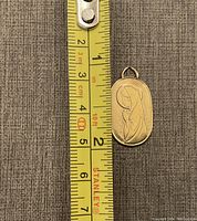Pendant on measuring tape showing length and width