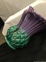 Closeup side view of the thistle-shaped jug highlighting shape and glaze colors