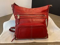 Front view showing front zippered pockets, pebbled leather texture and rivet details