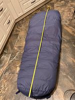 Sleeping bag laid flat with measuring tape showing length of 76 inches to confirm size