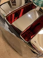 Close up image showing two wide slots of a chrome toaster with glowing red heating coils inside and light surface scratches on the exterior.