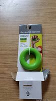 Front view of light green Gaiam Hand Grip Rondelle on cardboard packaging placed on wooden surface
