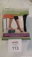 Photo of the front of the box showing product name, usage instructions and a person using the foot roller.