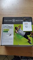 Front of the Gaiam Stability Ball Kit box showing branding, product name, and image of a person exercising on the green stability ball.
