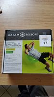 Front image of the Gaiam Restore Stability Ball Kit box showing product name and a man exercising on a green stability ball.