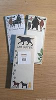 Front view of three magnetic notepads with animal and music themed designs on wood surface.
