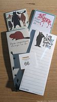 Front view of 4 magnetic notepads showing animal illustrations and puns on lined paper