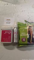 Full view of 3 yoga mat cleaning items including Gaiam wipes, Jogi wipes container, and Jogi spray bottle.