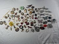 Wide shot showing the full assortment of brooches laid out on a white background showcasing the diversity and quantity.