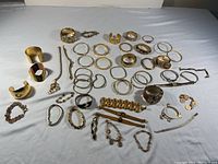 Full view of all bracelets and bangles in the lot arranged on a white surface.