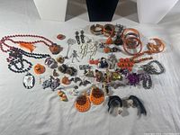 Full view of the lot showing various Halloween-themed jewelry items including necklaces, bracelets, watches, pins, earrings, and rings arranged on a surface.