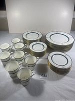 Full set of Mikasa Car38 Regalaire showing 8 dinner plates, 8 salad plates, 8 dessert plates, and 8 cups with saucers arranged on a table.