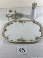 Photo showing rectangular Nippon serving tray with grapevine and floral pattern, small vase, and covered candy dish on metal stand