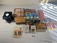 Overview of multiple decks of playing cards and card holders arranged on a white surface with natural light.