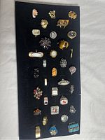 Overview of 30 assorted costume jewelry rings displayed on a black organizer with various styles and colors.