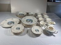 Full set of Royal Wessex Christmas dinnerware including plates, bowls, cups, saucers, serving platter, creamer, and sugar bowl arranged on white surface