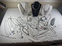 Tabletop layout of entire lot showing necklaces, bracelets and pendants