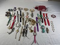 Full view of the entire lot displaying watches, bracelets, and small pouch on white background