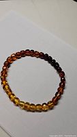 Top view of natural Baltic amber bracelet showing gradient of bead colors from yellow to dark brown.