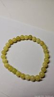 Photo of the lemon jade stretchy bracelet laid flat on a white surface showing bead color and detail.