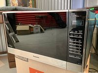 Front view of Panasonic stainless steel microwave showing control panel and door.